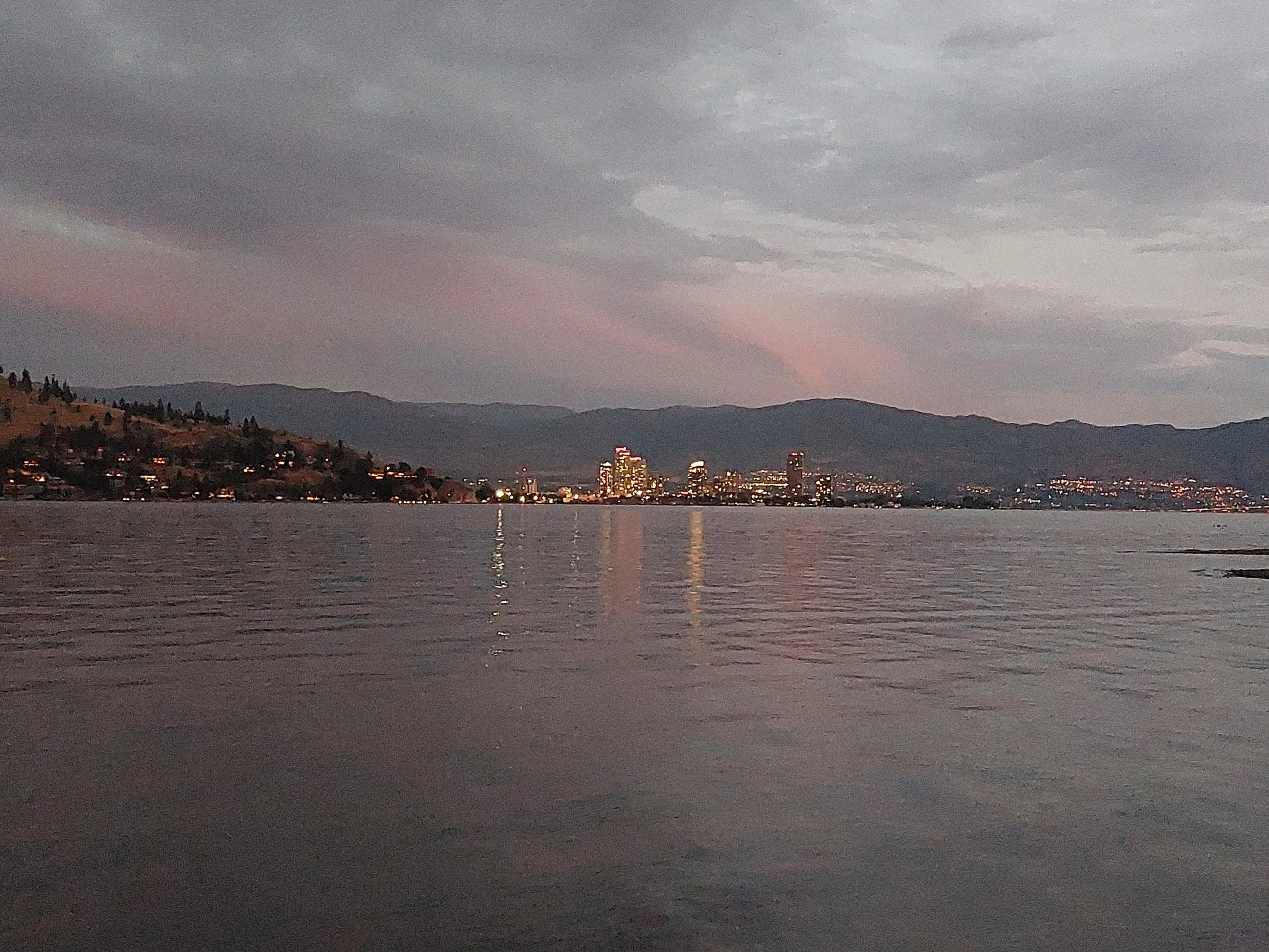 Kelowna in der Abenddämmerung vom Bear Creek aus gesehen.